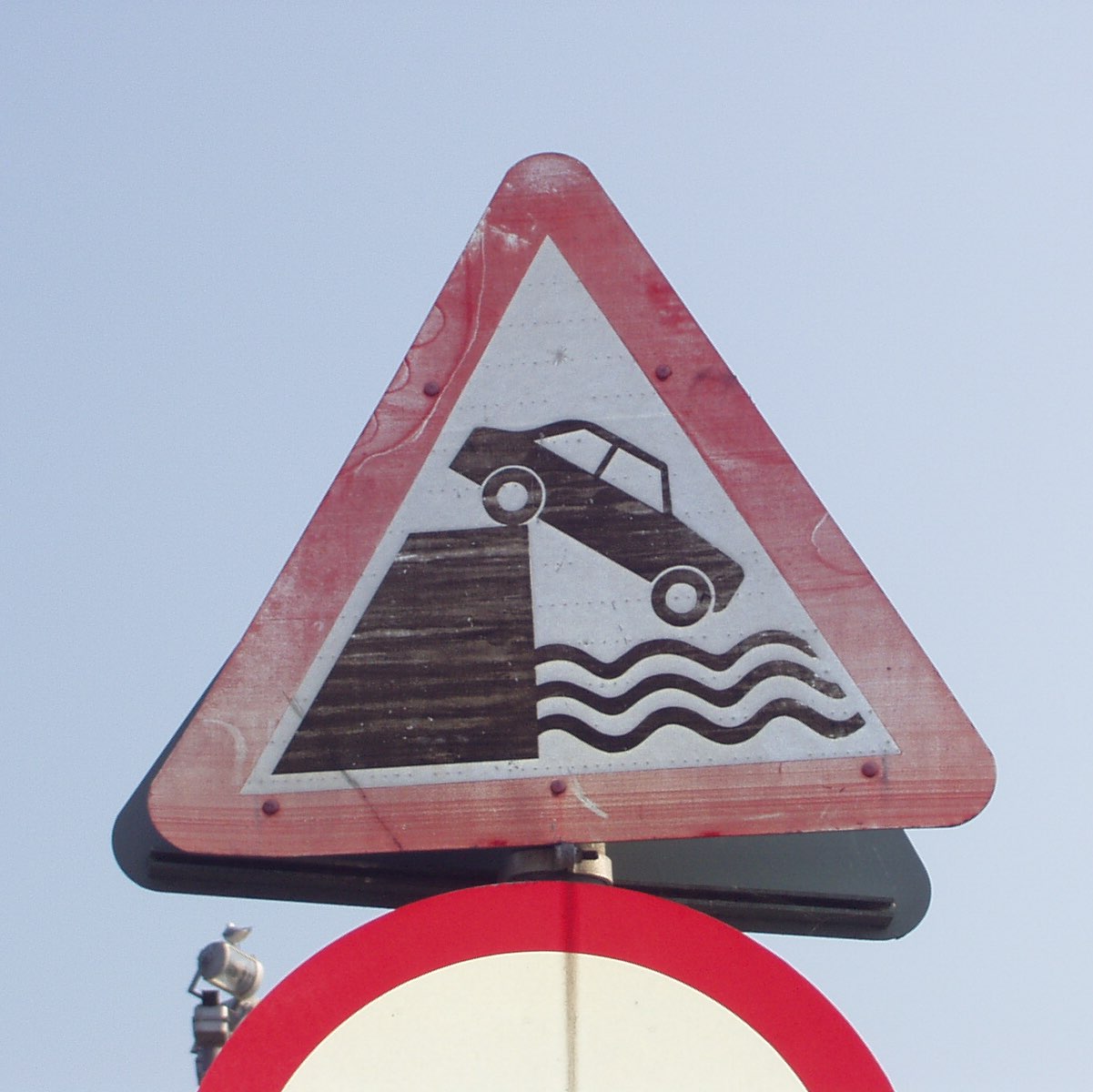 Sign depicting car driving into water.