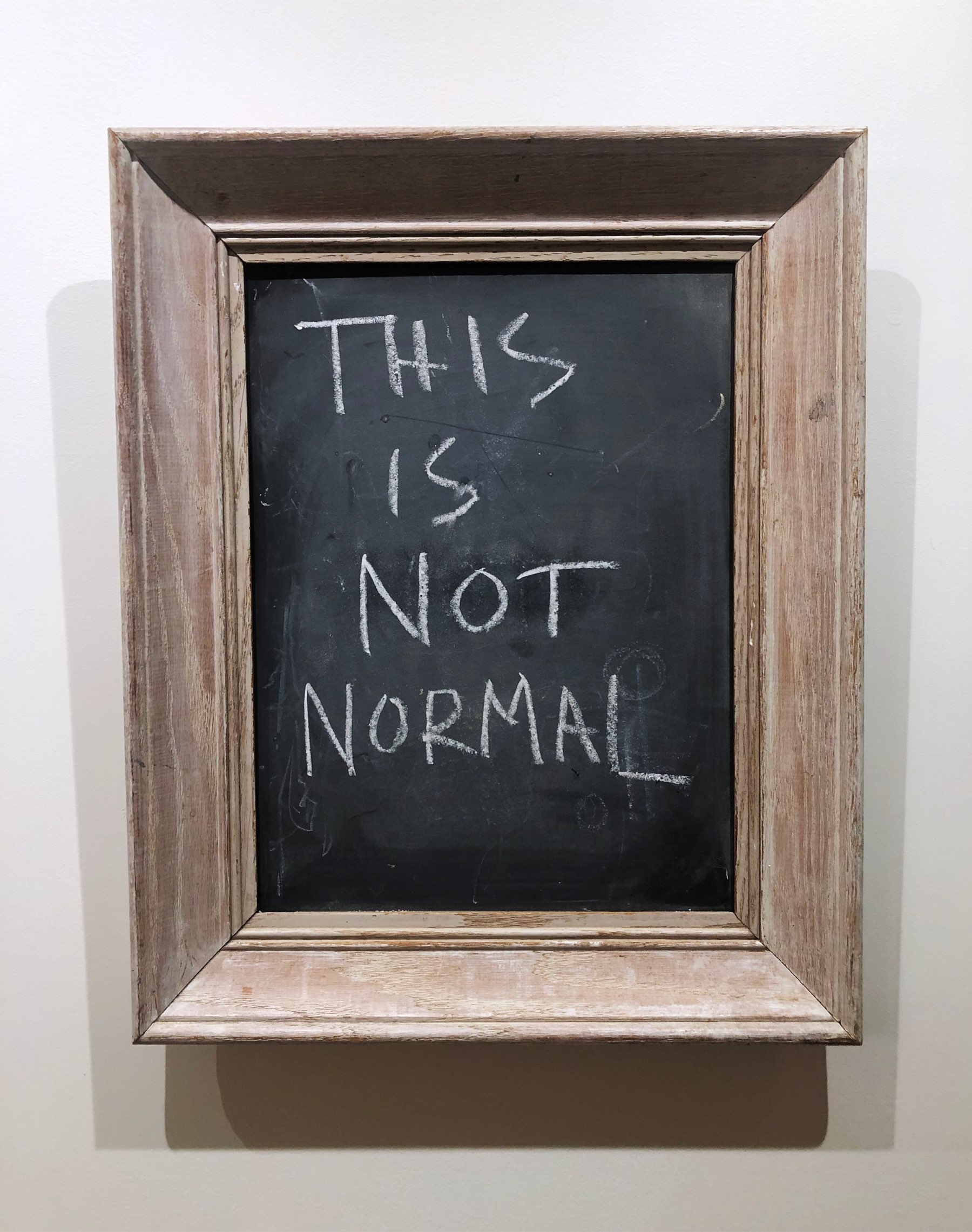 Chalkboard that reads “This is not normal”.